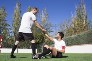 Jugador ayudando a levantarse a un compañero: recuperar la confianza tras un error